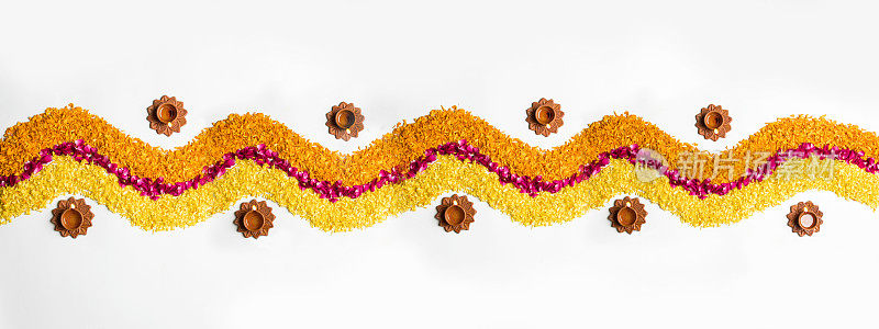 排灯节或pongal用金盏花或zendu花和红色玫瑰花瓣在白色背景上，排灯节Diwali diya在中间，选择性焦点